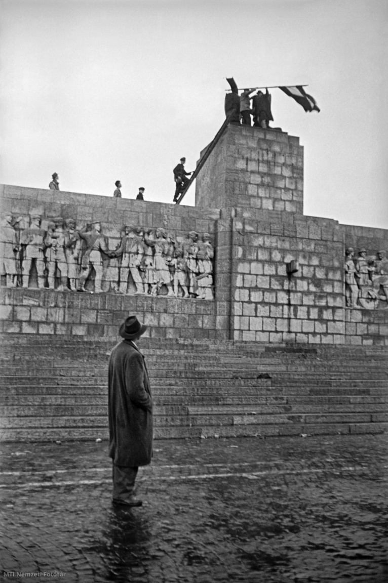 Budapest, 1956. október. Forradalmárok magyar zászlót tűznek a ledöntött Sztálin-szobor talapzatára, amelyből csupán a csizmás lábszárak maradtak meg a szobor október 23-i ledöntése után. A felvétel készítésének pontos időpontja ismeretlen