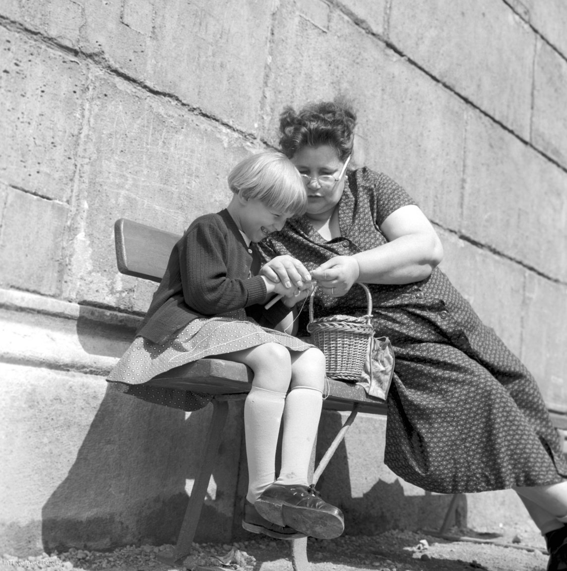 Budapest, 1959. szeptember 1. Anya horgolni tanítja kislányát a Múzeumkertben.