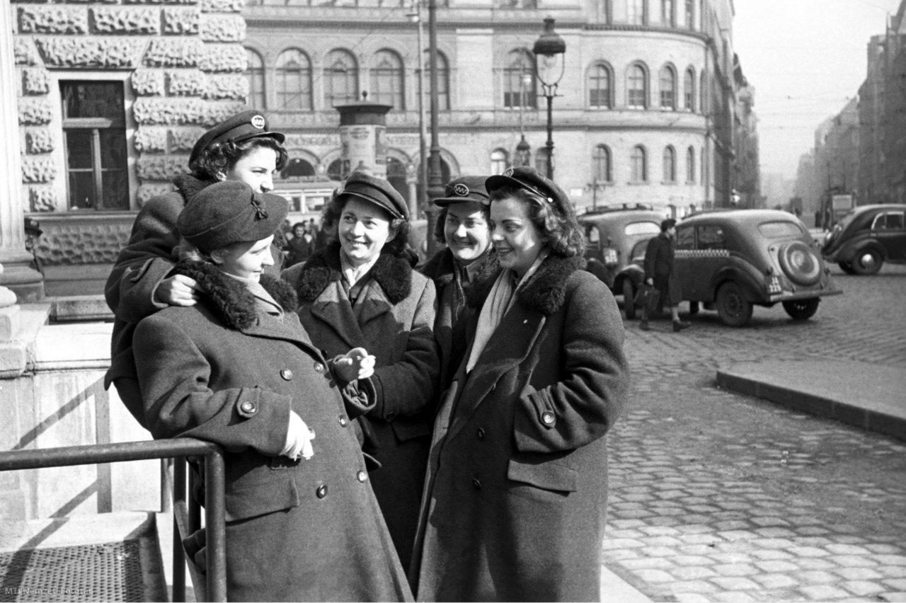 Budapest, 1952. február 27. Taxisofőrnők beszélgetnek a napsütésben, miközben utasra várnak a Nemzeti Színház oldalán, a Blaha Lujza téren lévő taxi állomáson.