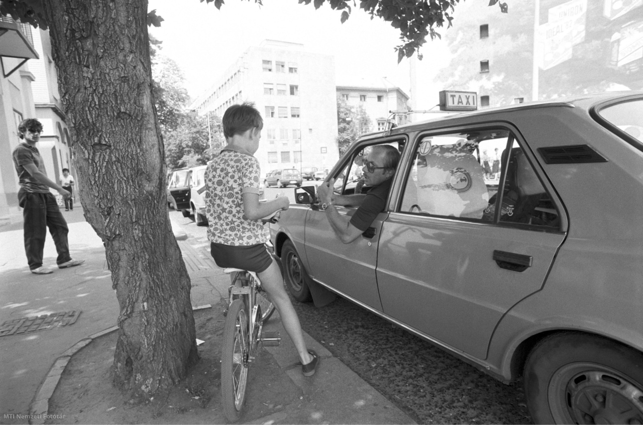 Budapest, 1986. július 16. Biciklis kisfiú beszélget egy taxissal a Kálvin téren.