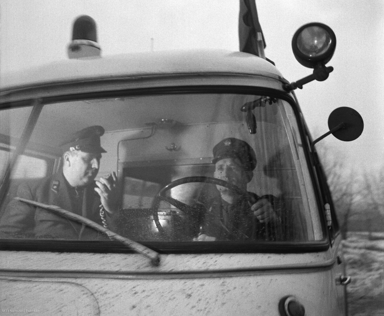 Tatabánya, 1966. február 5. Erzse József mentőápoló (b) és Pirka László gépkocsivezető a mentőautóban URH-készüléken tartják a kapcsolatot a tatabányai mentőközponttal. Az URH-készülékekkel Komárom megye is bekapcsolódott az országos rádióhálózatba, jelenleg a megye 6 helyiségével és 1 mentőautóval tart állandó kapcsolatot. A későbbiekben több mentőautót is felszerelnek URH-készülékkel