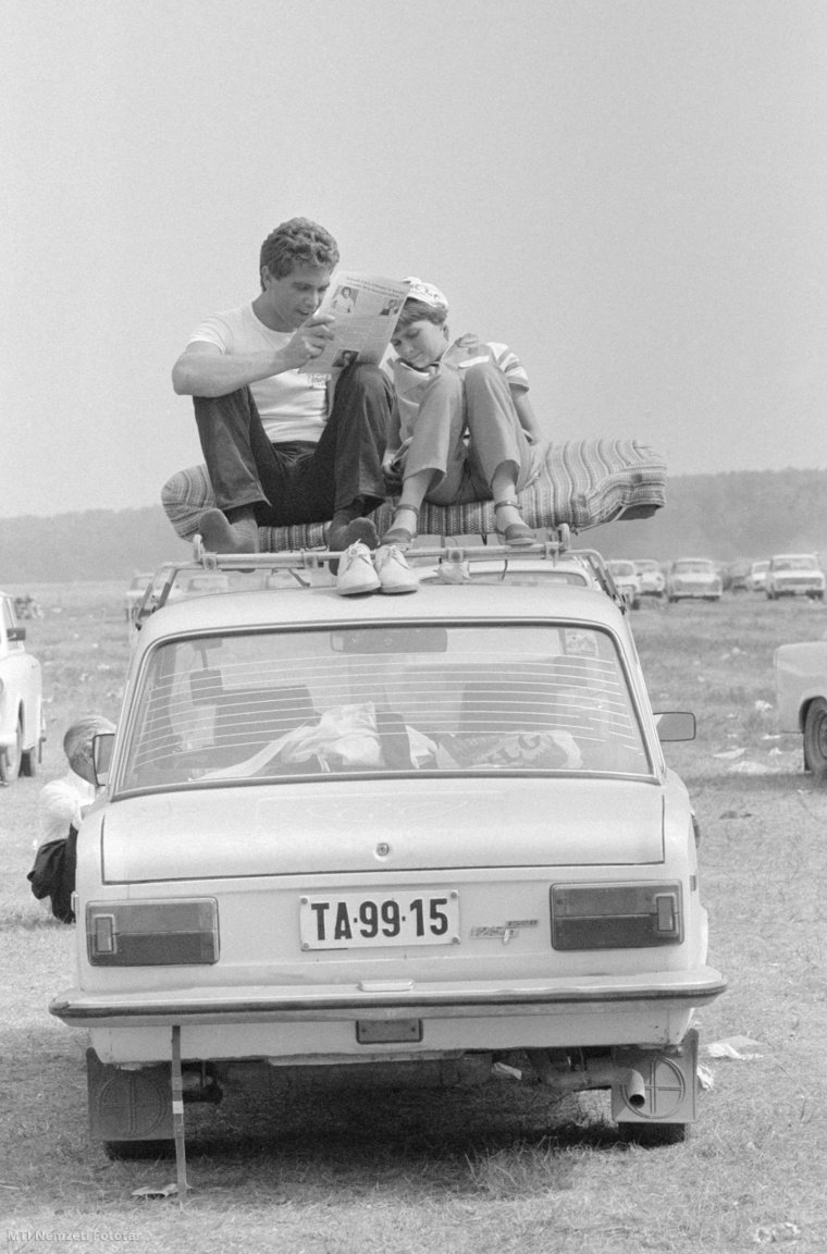 Pusztavacs, 1983. augusztus 7. Egy fiatal pár egy Polski Fiat 125-ös autó tetőcsomagtartóján ülve olvassa az újságot a Képes Újság és az Országos Béketanács által szervezett békefesztiválon, a Pest megyei Pusztavacson.