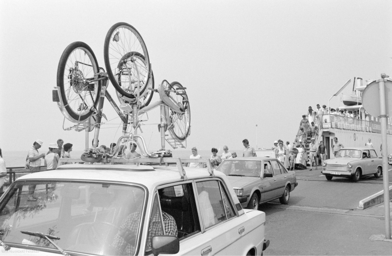 Szántód, 1983. július 20. Gépkocsik, közöttük egy a tetőcsomagtartóján kerékpárokat szállító személyautó gördül le a kompról Szántódon a kikötőben.
