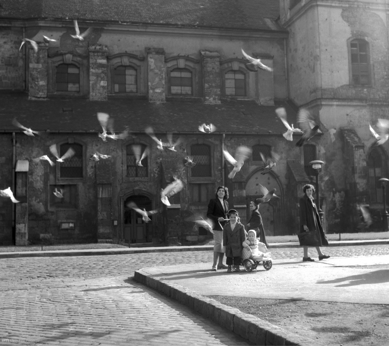 Budapest, October 8, 1957 Passers-by watch pigeons fly in the background of Downtown Church on March 15 Square