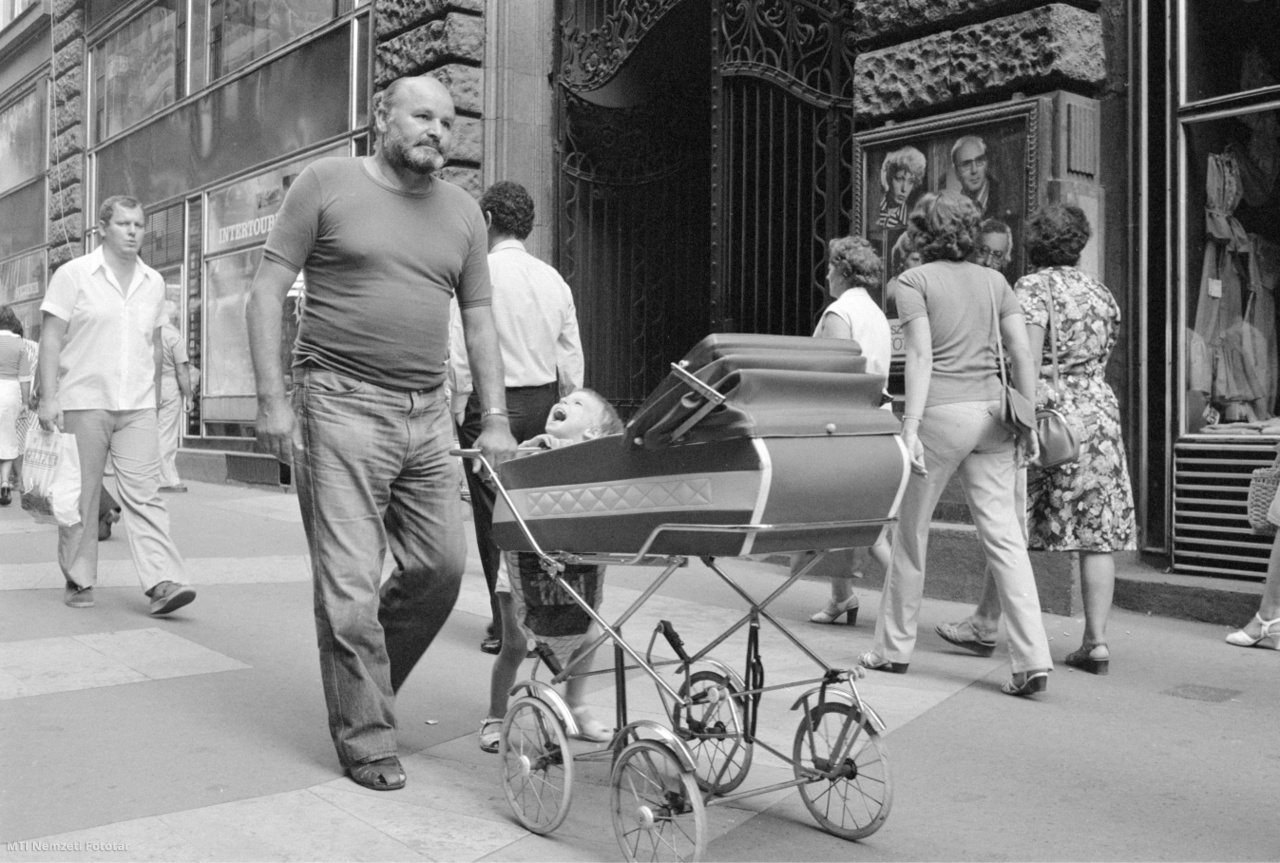 Budapest, August 10, 1982. A father pushes his child into a stroller on Gijio Street