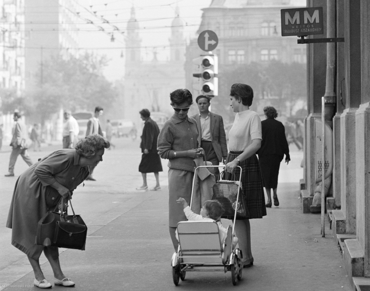 Budapest, June 10, 1961 Passengers at a bus stop on Burroughs Street: A small child talking to a girl