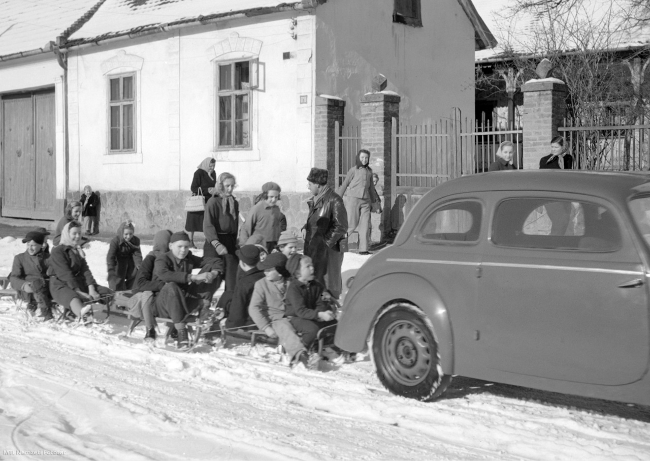 Visegrád, 1956. január 29. Személyautó lökhárítójára csatlakozó szánkózók egy visegrádi havas utcán