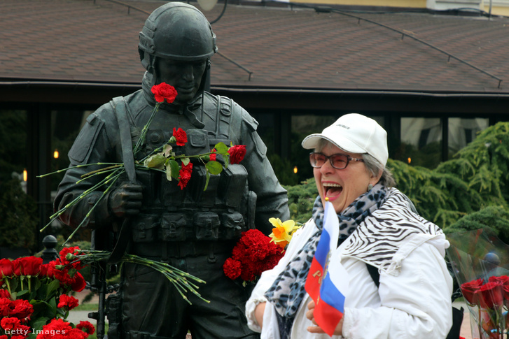 Egy nő az „udvarias zöld emberek” emlékműve mellett áll 2021. március 16-án