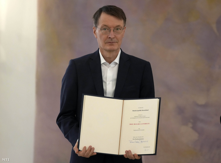 Karl Lauterbach egészségügyi miniszter kezében a Frank-Walter Steinmeier német elnöktől átvett megbízólevelével az új német kormány tagjainak kinevezési ünnepségén a berlini államfői rezidencián 2021. december 8-án