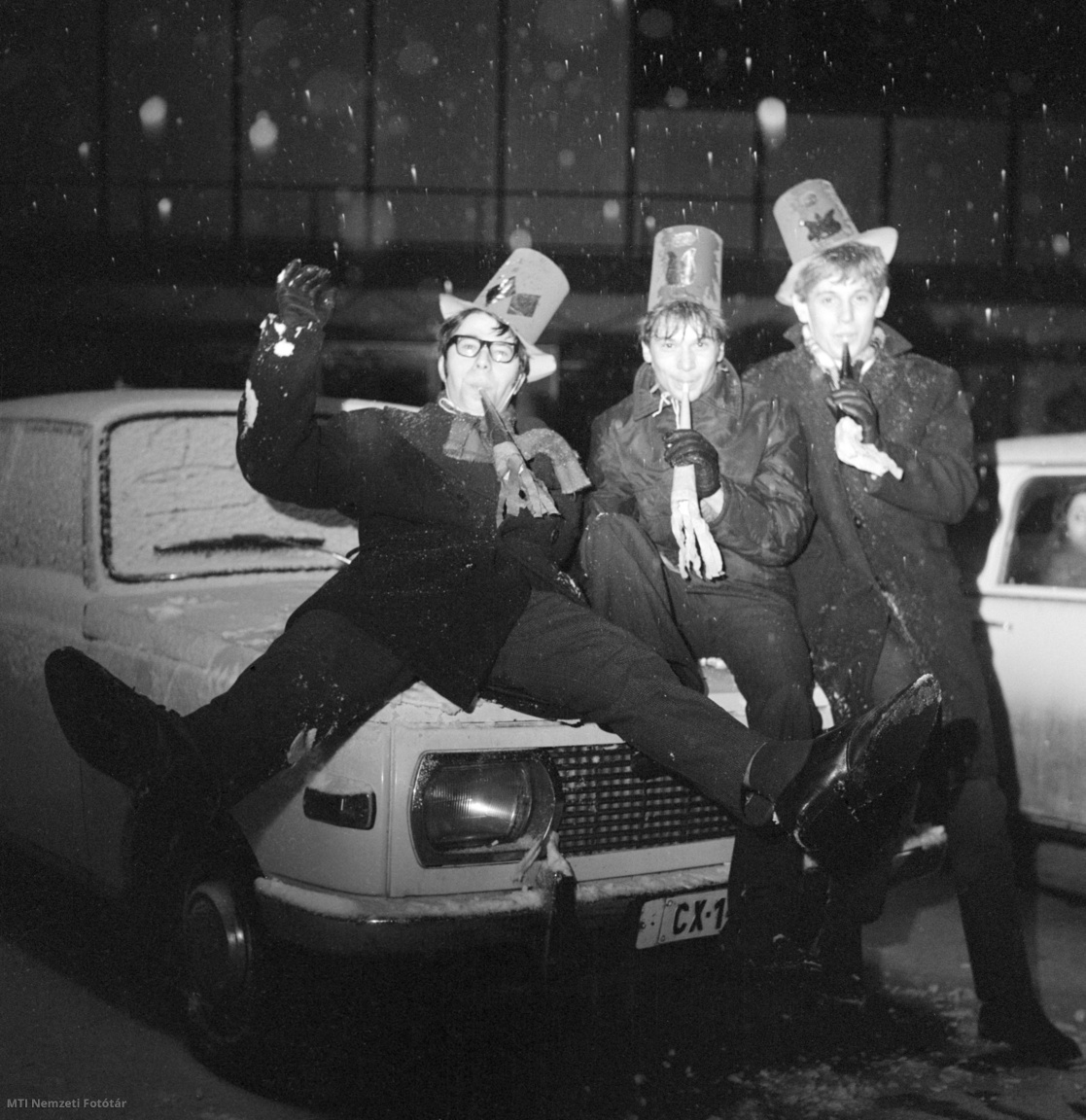 Budapest, 1971. január 1. Egy Wartburg motorházán ülve trombitál három fiú szilveszter éjszakáján a Blaha Lujza téren
