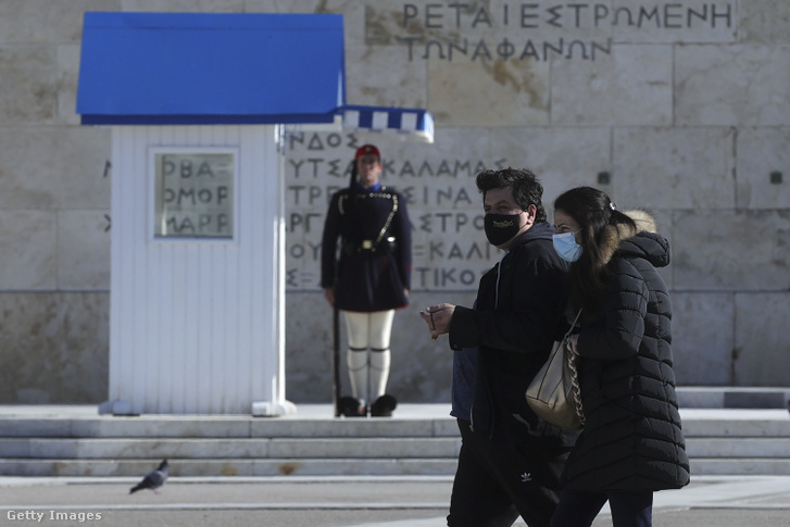 Maszkot viselő járókelők Athénban 2021. december 23-án
