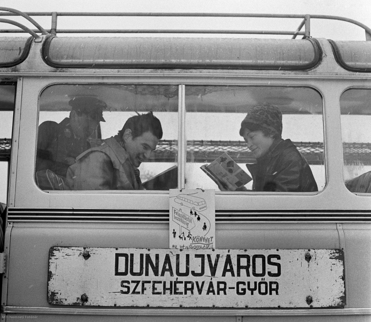 Dunaújváros, 1965. február 18. Utasok olvasnak a Magyar Államvasutak Közúti Gépkocsiüzeme (MÁVAUT) Dunaújváros- Székesfehérvár-Győr útvonalon közlekedő autóbuszán. A járaton utazás közben válogathatnak, olvashatnak a kísérleti utas könyvtár köteteiből, melyet úgy válogatták össze, hogy rövid írásműveket, kisregényeket, novellákat, verseket, karcolatokat tartalmazzanak. Az utasok 55 könyv közül kölcsönözhetnek az utazás idejére. Már az első napon nagy forgalma volt az autóbuszkönyvtárnak, amely ha beválik, akkor a szolgáltatást kezdeményező Fejér megyei Vörösmarty Könyvtár más távolsági járaton is rendszeresíti majd a könyvkölcsönzést.