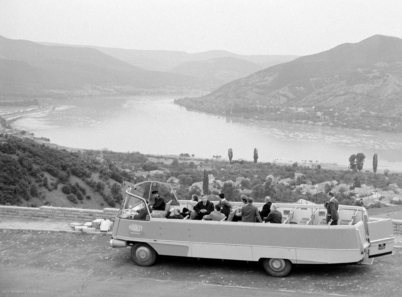 Visegrád, 1965. augusztus 5. A Finta László formatervező által, az Ikarus 31 típusú autóbusz fő darabjainak felhasználásával tervezett, a Magyar Állam Vasutak Autógépkocsi-üzeme (Mávaut) üzemeltetésében lévő panorámabusz első próbaútján turistákkal a nemrégiben elkészült, a visegrádi Fellegvárhoz és a Nagyvillám-kilátóhoz (Zsitvay-kilátó) vezető Panoráma úton. A Pest megyei Idegenforgalmi Hivatal felkészült az idegenforgalomra, így a visegrádi hajóállomástól nyitott panorámabusz viszi fel a hegyre a kirándulókat. Felújították a Nagyvillám-kilátót is, a tetőteraszán monokuláris távcsövet állítottak fel. Háttérben a Duna folyó