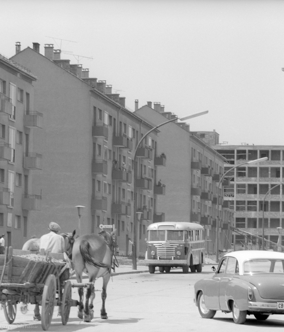 Pécs, 1961. június 26. Utcai forgalom lovas kocsival, Volga M–21-es személyautóval és autóbusszal – Ikarus 30-as távolsági autóbusz – Pécs épülő délnyugati városrészében, az Uránvárosban. Uránvárost az uránbányák megnyitása és üzemeltetése hívta életre. 1940 és 1956 között repülőtér volt ezen a területen. 1956-ban kezdtek lakóházakat építeni a bányászok számára, tervezője Dénesy Ödön Ybl-díjas építész