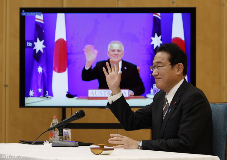 Kisida Fumio japán miniszterelnök (j) int Scott Morrison ausztrál miniszterelnöknek (a kijelzőn), miután egy virtuális csúcstalálkozó keretében aláírták a Kölcsönös hozzáférés egyezménye elnevezésű védelmi megállapodást a tokiói kormányfői rezidencián 2022. január 6-án