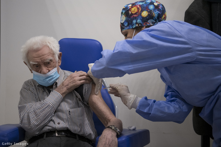 Egy egészségügyi dolgozó Pfizer-BioNTech Covid-19 vakcinát fecskendez be egy 100 éves férfinek 2021. március 18-án Torinóban