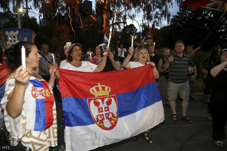 Djokovics szurkolói szerb zászlóval és gyertyával a kezükben énekelnek egy kiutasítottaknak fenntartott melbourne-i szálloda elõtt
