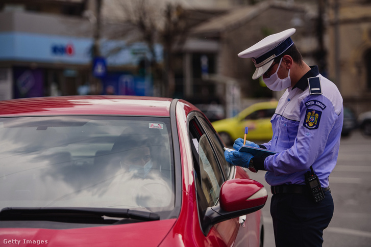 Rendőr igazoltat egy sofőrt Bukarestben 2020. május 5-én