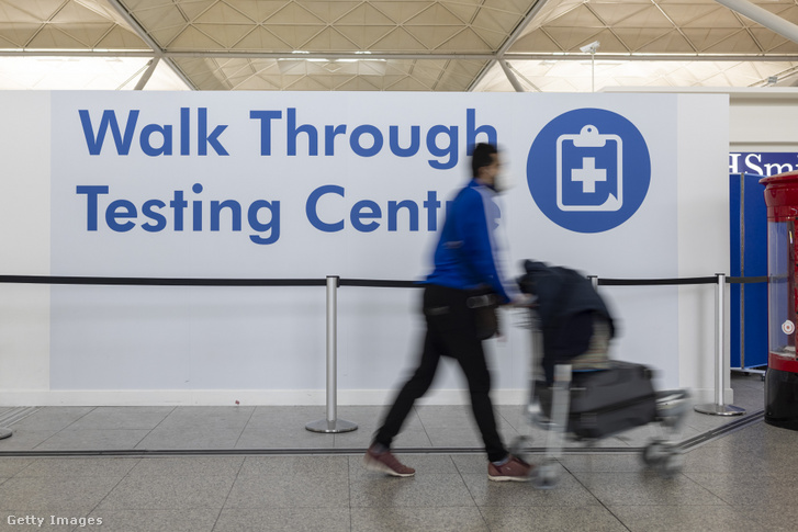 Utas halad el a londoni Stansted repülőtéren lévő koronavírus tesztelő mellett 2022. január 10-én