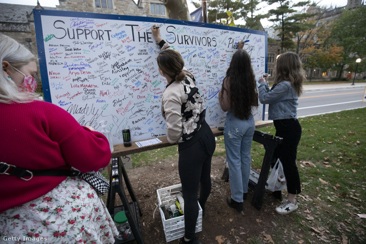 A szexuális zaklatás túlélőit támogató táblát írják alá a Michigani Egyetem leköszönő elnökének, Mark Schlisselnek a háza előtt 2022. január 22-én