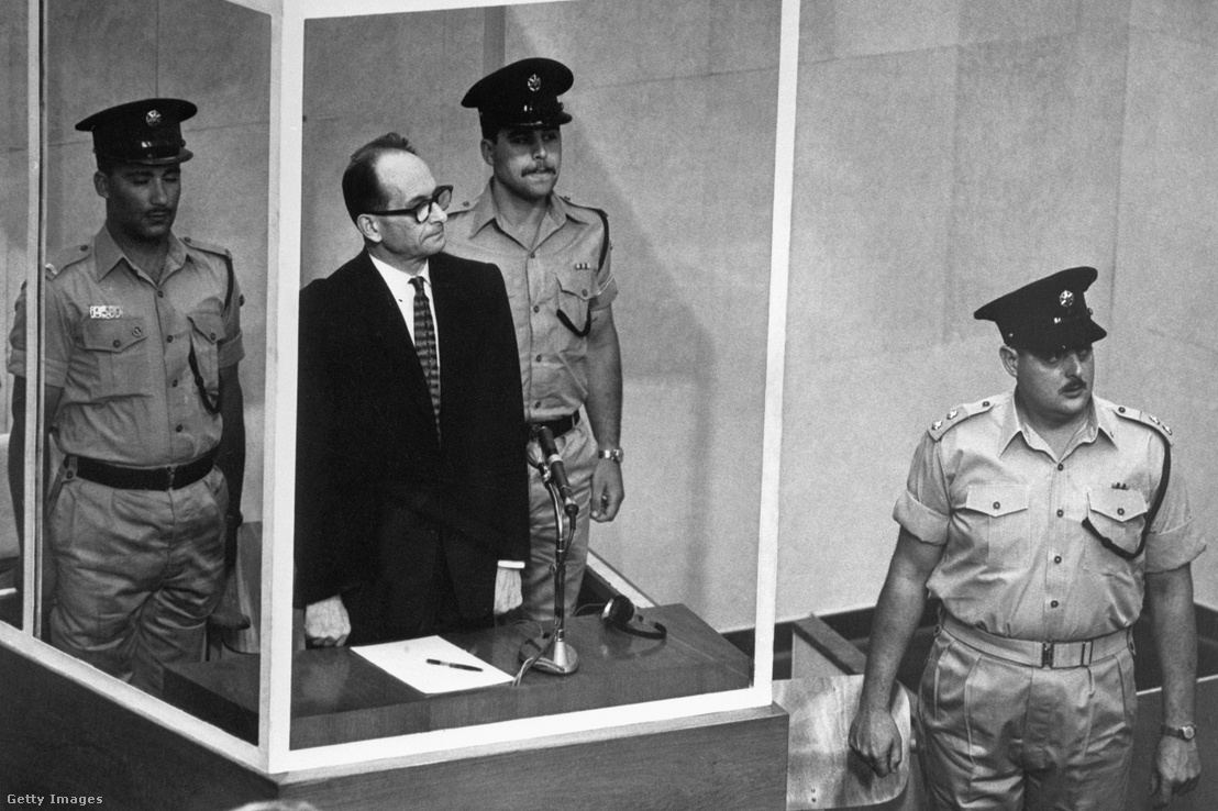 Adolph Eichmann egy fülkében áll az izraeli rendőrség mellett 1961. június 22-én Jeruzsálemben