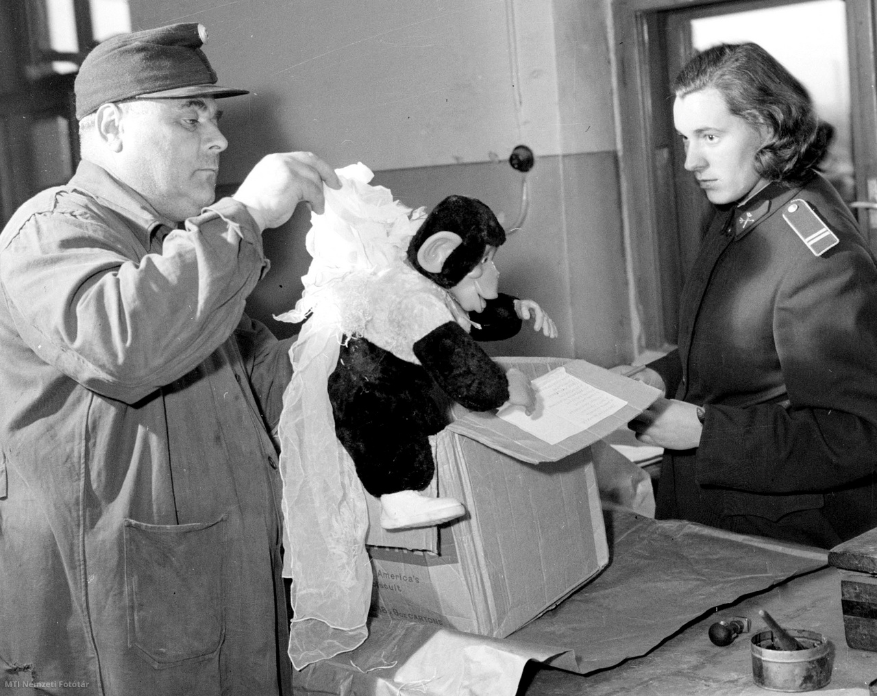 Budapest, 1958. május 6. Havonta mintegy 50 000 csomag érkezik Budapestre külföldről. A csomagok nagy része simán teszi meg az utat a vagonoktól a vámszemléig és a címzettig. Akad azonban olyan, amelyik fennakad az ellenőrzés során. A postás elrejtett nejlonsálakat szed ki az ajándék majom hátából.