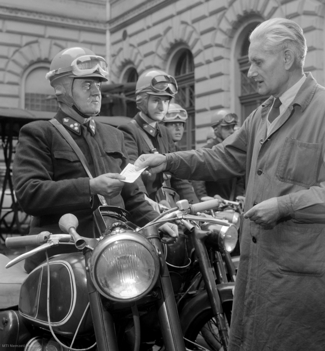 Budapest, 1963. október 8. Kézbesítendő küldeményt vesz át egy motoros postás a Posta Igazgatóságon. A munkáltató zöld színű bukósisakokat osztott ki az expressz leveleket és táviratokat kézbesítő postásoknak, ezzel az alkalmazottak biztonságosabb közlekedését kívánja elősegíteni.