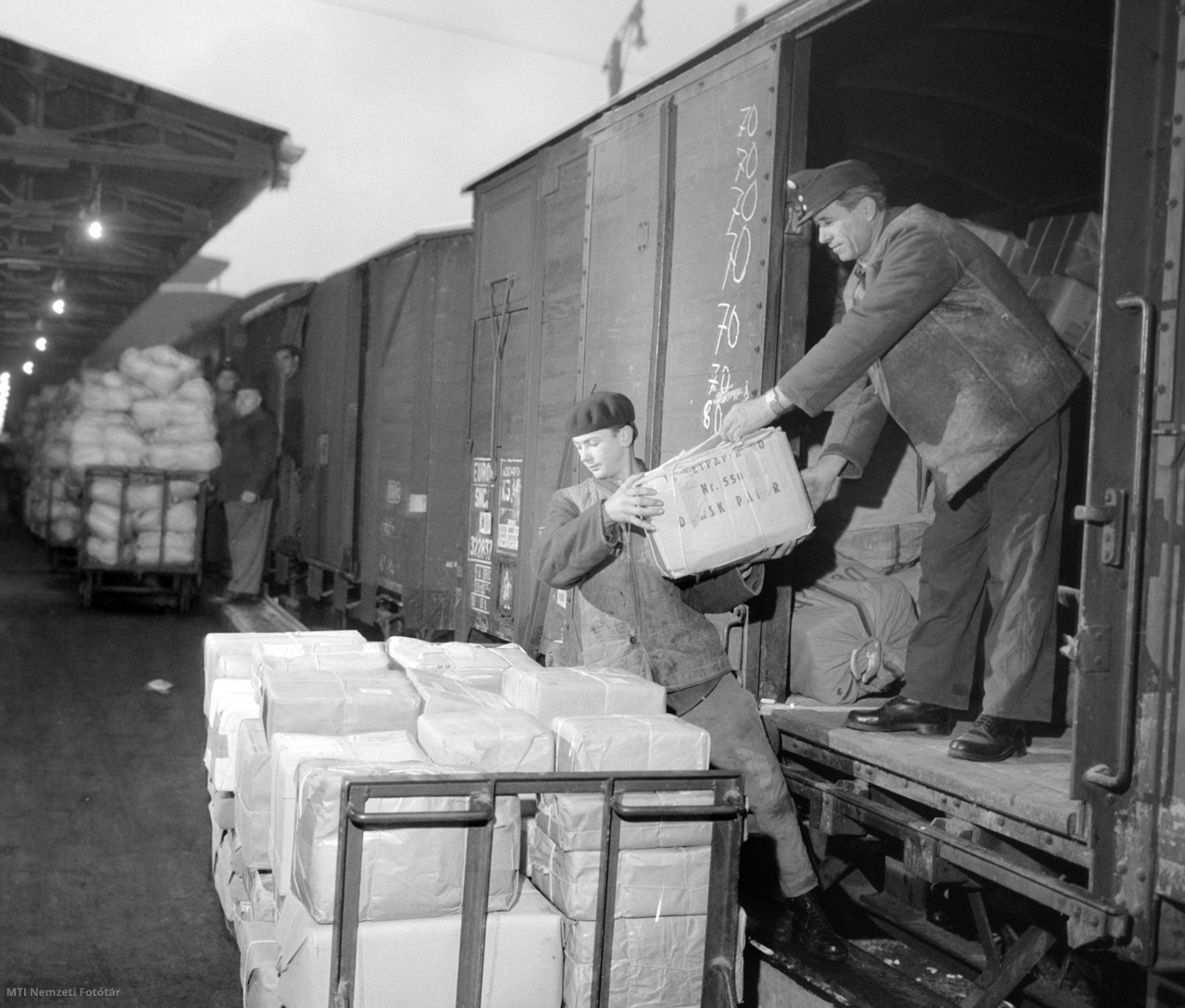 Budapest, 1964. december 8. A Verseny utcai 70-es számú postahivatal dolgozói lepakolják a tehervonatról a Német Szövetségi Köztársaságból érkezett karácsonyi ajándékcsomagokat.