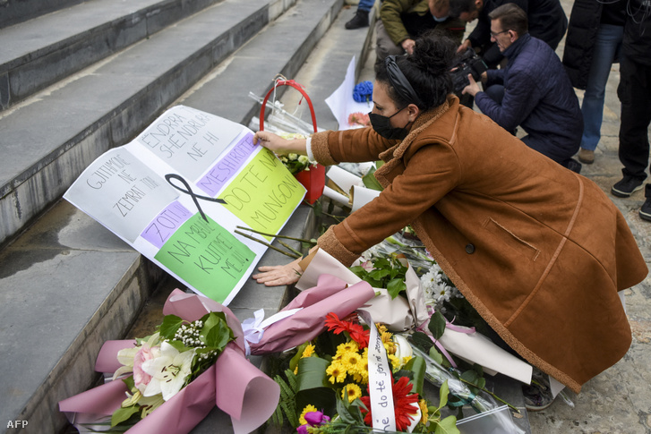 Egy nő virágot helyez el az eldozatok emlékhelyén Szkopjében 2021. november 24-én