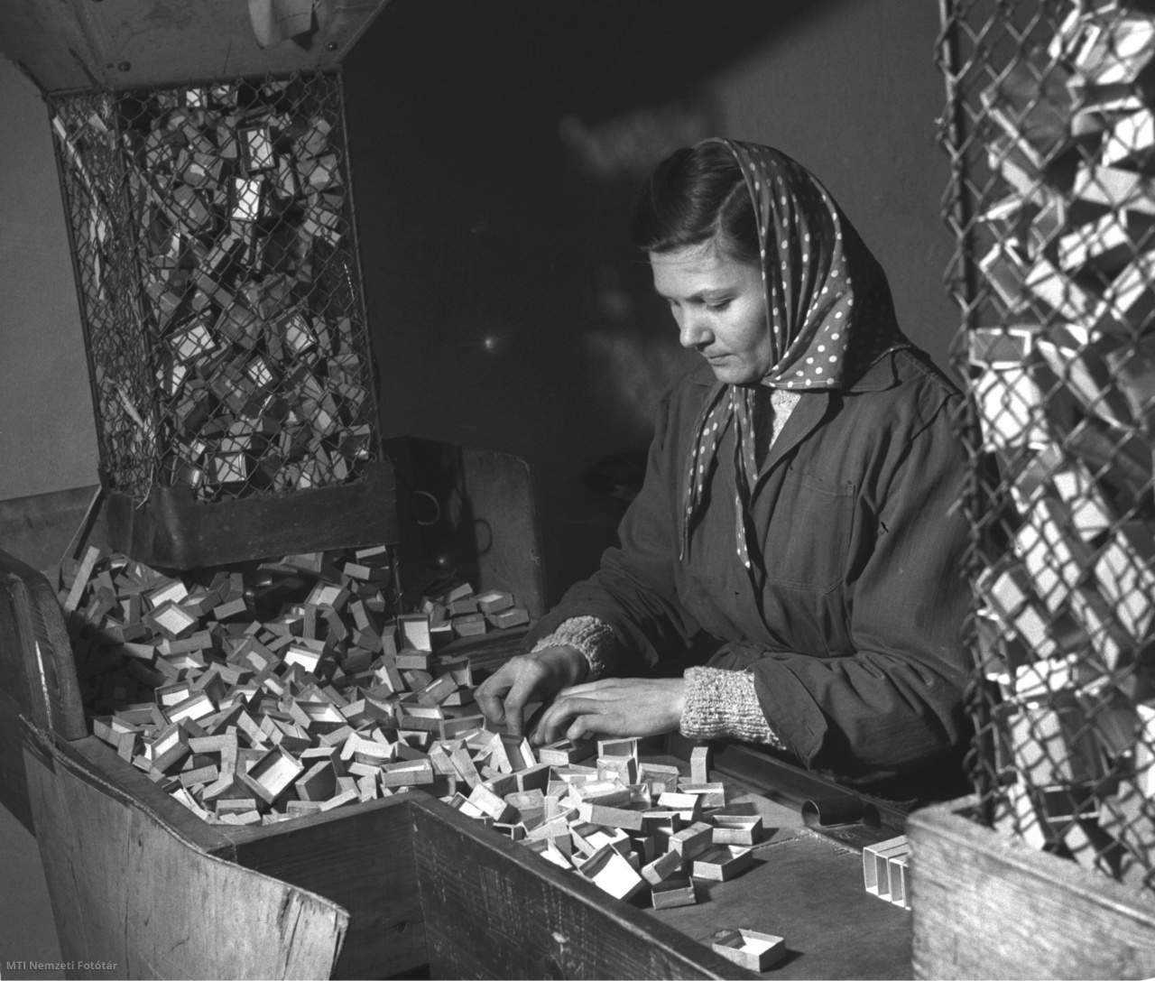 Kecskemét, 1956. február 5. Kovács Ferencné címkézőgépbe rakja a készülő gyufásdobozokat a Kecskeméti Gyufagyárban.