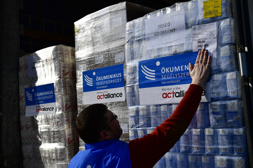 Az Ökumenikus Segélyszervezet munkatársa segít a segélyszervezet kétkamionnyi, több mint 28 tonna tartósélelmiszer-adománya útnak indításakor Kárpátaljára.