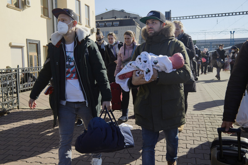 Két német állampolgár, Adam (balra) és Boris (jobbra) a vonathoz igyekeznek, hogy távozzanak Kijevből. Mindkettőjüknek ukrán béranyától született gyermeke, Adam kisfia csak kéthetes, Boris babája pedig mindössze kétnapos volt a fotó február 28-i készültekor. Feleségeikkel együtt rajta voltak a német nagykövetség evakuálási listáján.