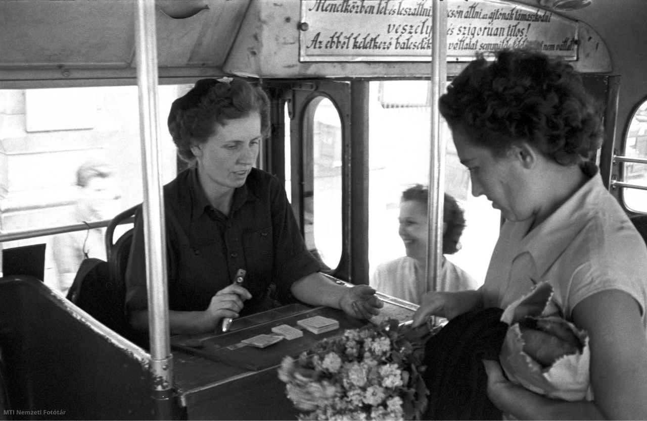 Budapest, July 19, 1958 A woman buys a ticket on the trolleybus from the guide. 