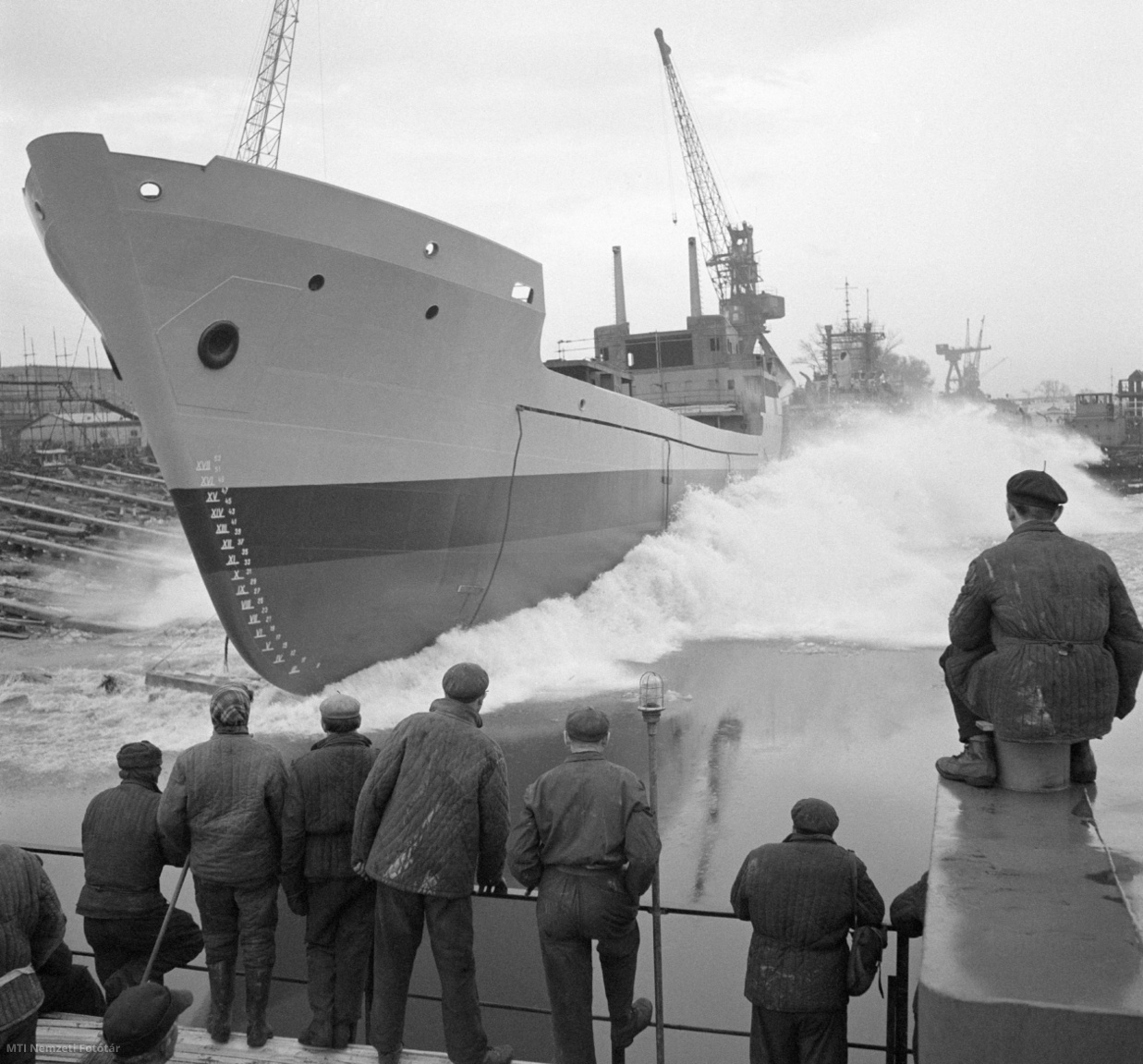 Budapest, 1966. február 7. A Magyar Hajó- és Darugyár angyalföldi gyáregységében vízre bocsátják az idei évben elkészült első tengerjáró hajót. Az 1200 tonnás, 62-es számú hajó vízre bocsátása a vastag jégpáncél miatt késett, de most is jégtörő hajó készített helyet a jégtáblák között a vízre csúszó hajótestnek
