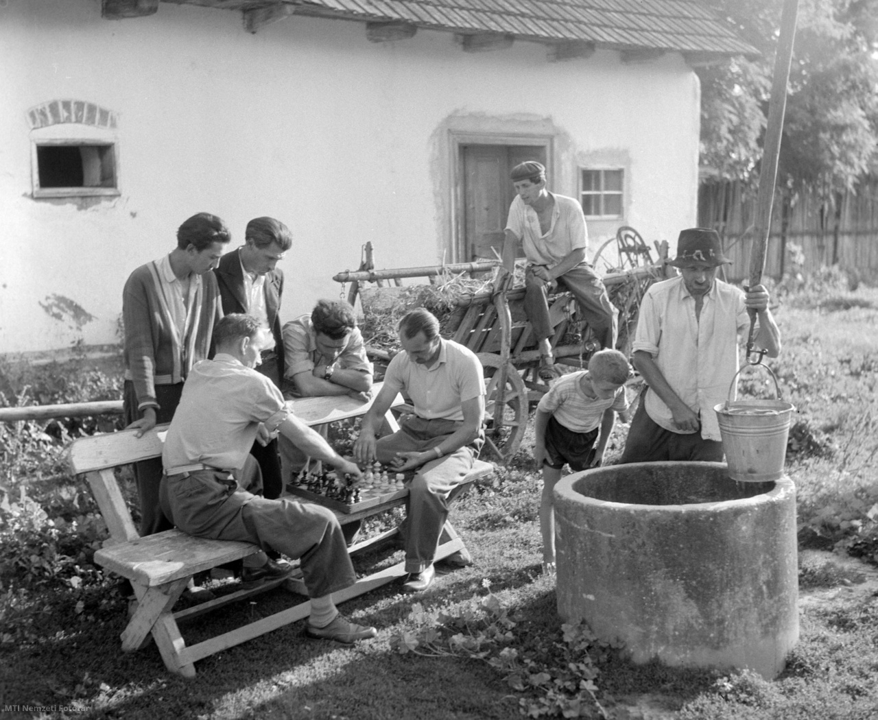Rozsály, 1958. július 13. A rozsályi falusi sportkör tagjai figyelik két sakkozó társukat munka után egy ház udvarán, mellettük egy férfi vizet húz a gémeskútból
