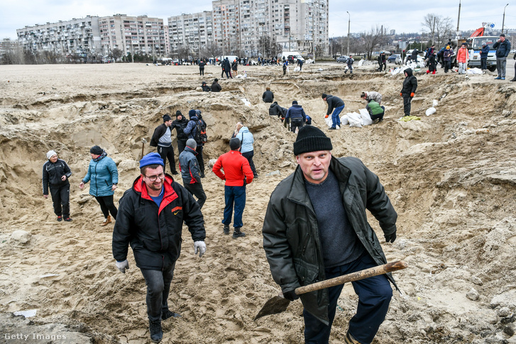 Helyi lakosok homokzsákokat töltenek az orosz hadsereg elleni torlaszokhoz Zaporizzsjában 2022 március 4-én