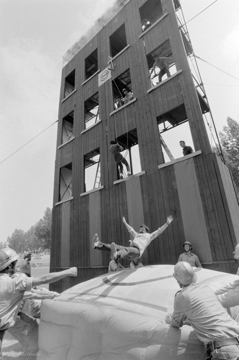 Szekszárd, 1986. július 6. Többemeletes lakóházból való mentést, annak módozatait – mászókötél, ugrópárna – mutatják be a 12. országos tűzoltóverseny résztvevői Szekszárdon.