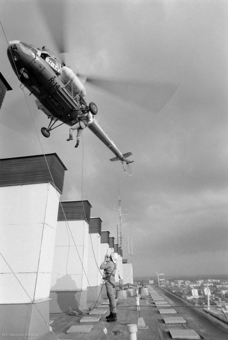 Budapest, 1990. október 9. Tűzoltó ereszkedik le egy helikopterről a Semmelweis Orvostudományi Egyetem Nagyvárad téri épületének tetején. A SOTE épületén a középmagas és magas házak oltási, mentési munkálatait gyakorolták a tűzoltók.