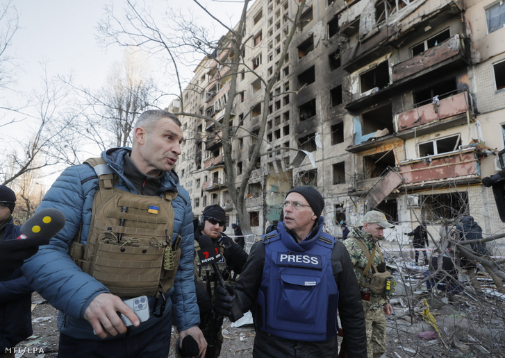 Vitalij Klicsko kijevi polgármester (b) újságírók kérdéseire válaszol egy tüzérségi támadásban megrongálódott lakóépület mellett Kijevben 2022. március 12-én