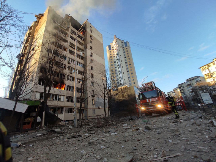 Tűzoltók dolgoznak egy tüzérségi támadásban megrongálódott lakóháznál Kijevben, Ukrajnában 2022. március 16-án