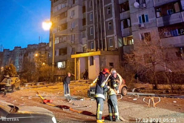 A mentőcsapat tagjai dolgoznak, miután egy rakéta maradványai megrongáltak egy lakóépületet Kijevben 2022. március 17-én