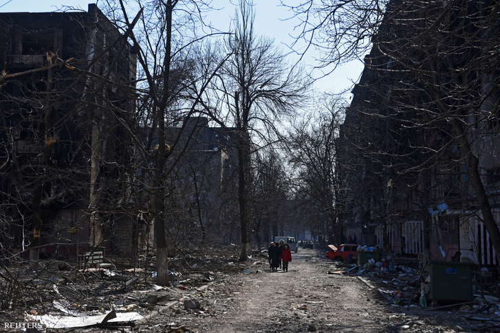 Helyi lakosok egy támadásban megsemmisült lakóövezetben Mariupolban 2022. március 18-án