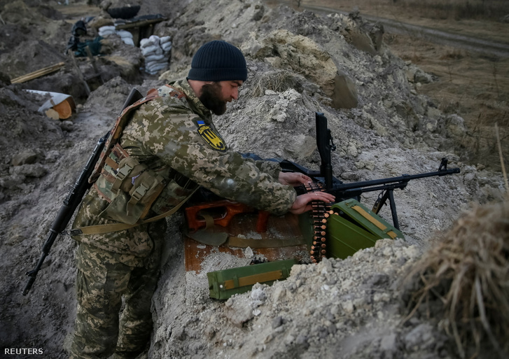 Egy ukrán katona a géppuska töltényeit ellenőrzi a frontvonalon az észak-kijevi régióban 2022. március 24-én