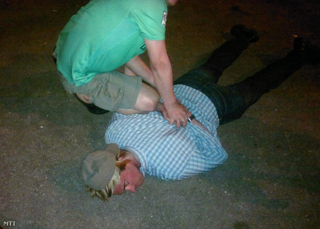 Az orosz Szövetségi Biztonsági Szolgálat (FSZB) által közreadott képen a biztonsági szolgálat egyik munkatársa térdepel a földön fekvő Ryan Christopher Fogle-ön.