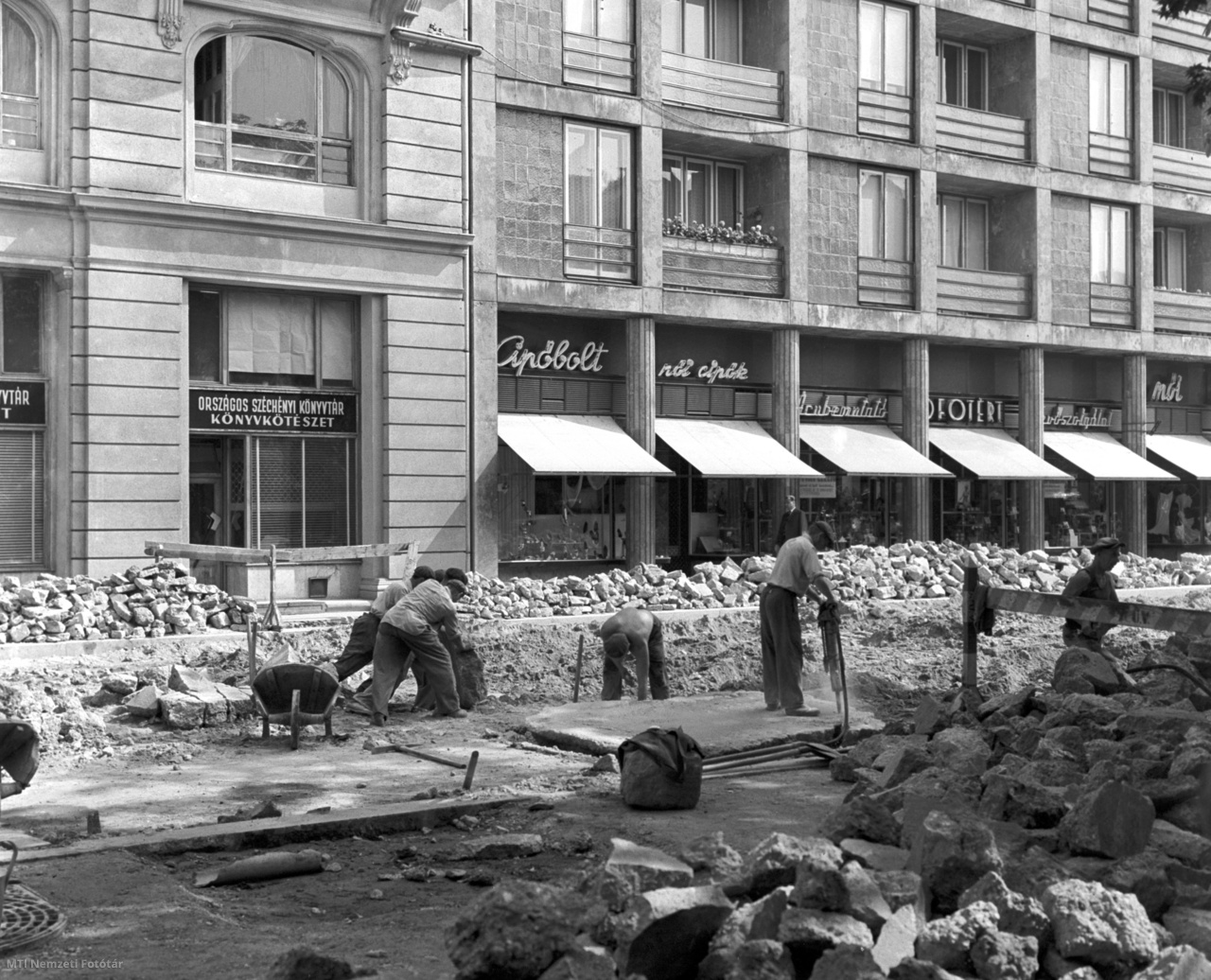 Budapest, 1964. július 15. Építőmunkások, kubikosok dolgoznak a belvárosi József Attila utca felújításán. Az Útburkoló Vállalat dolgozói megkezdték az úttest kialakítását, és a tervek szerint augusztus végén át is adják a forgalomnak a megújult négysávos utcát.