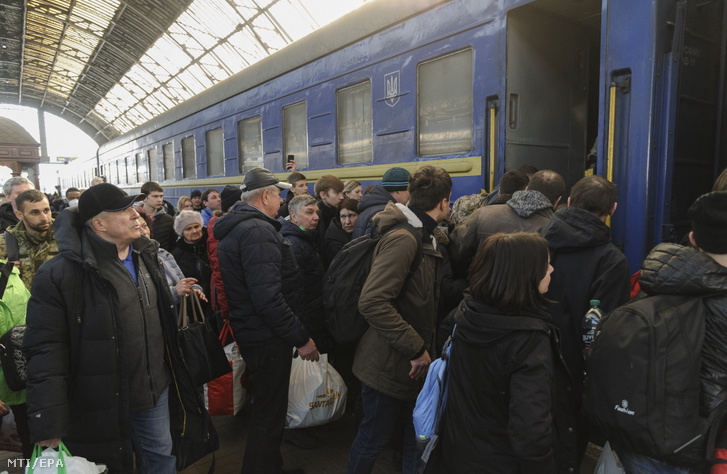 A háború elől Ukrajnából menekülő emberek egy Lengyelországba tartó vonatra szállnak a nyugat-ukrajnai Lvivben 2022. március 15-én