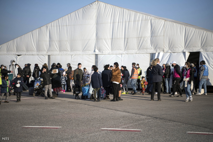 Ukrajnából érkezett menekültek a számukra létesített fogadóközpont bejárata előtt