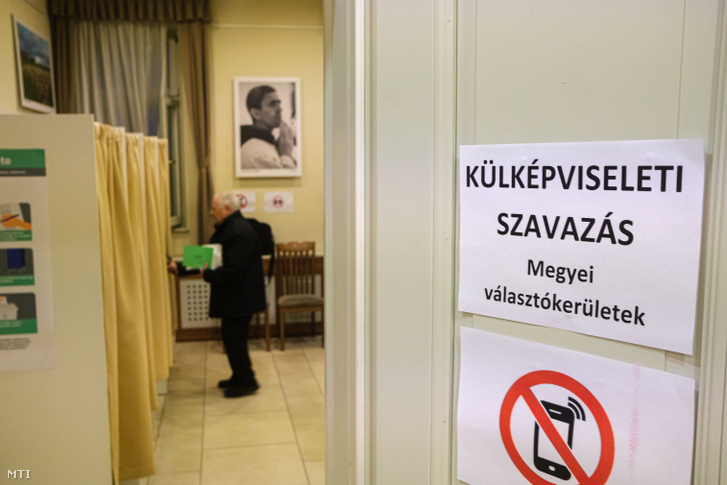 Belép a szavazófülkébe egy választópolgár a magyarországi országgyűlési választáson és gyermekvédelmi népszavazáson Magyarország csíkszeredai főkonzulátusán 2022. április 3-án