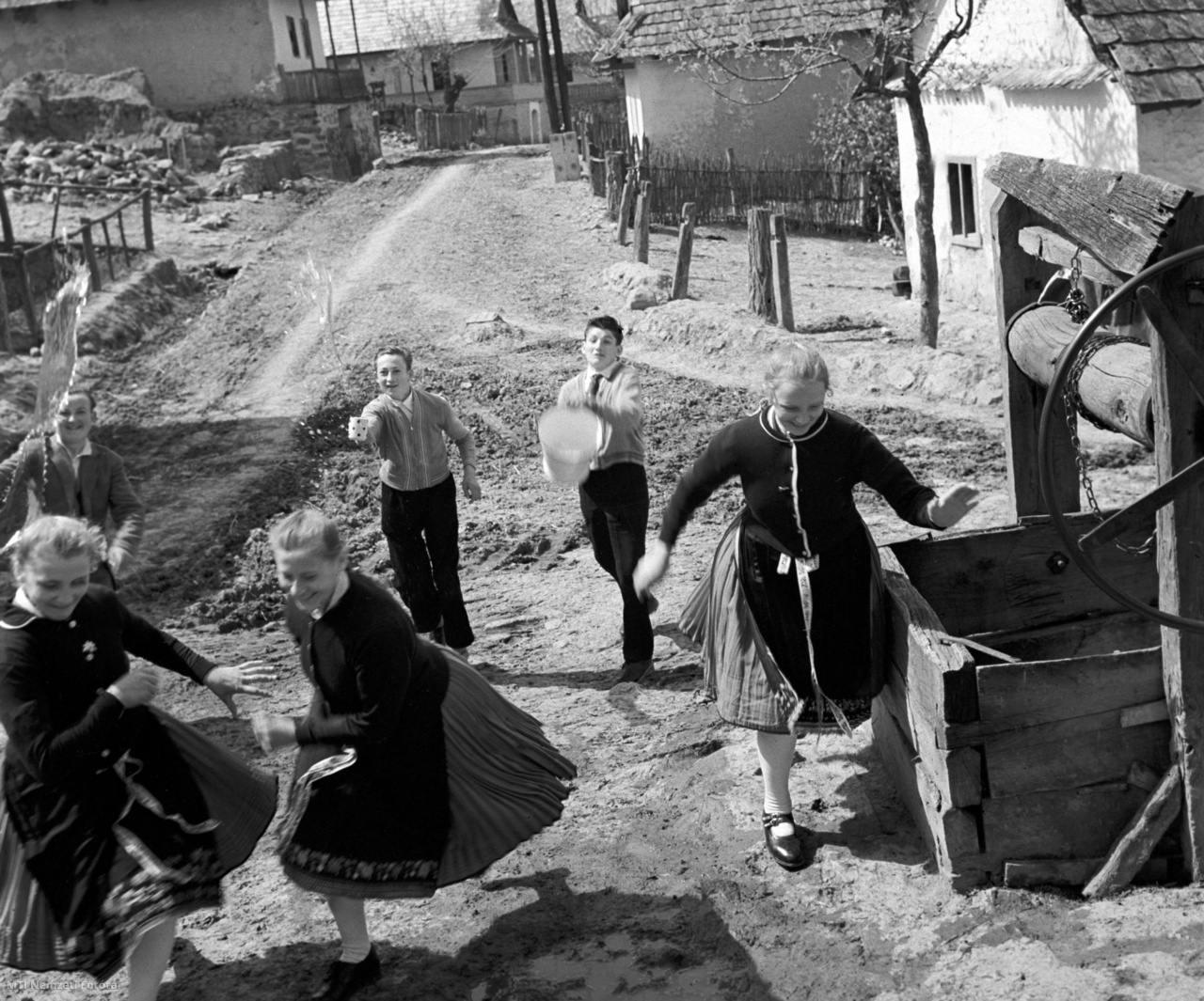 Hollókő, 1960. április 18. A menekülő leányokat locsolják húsvéthétfőn a hollókői legények. 