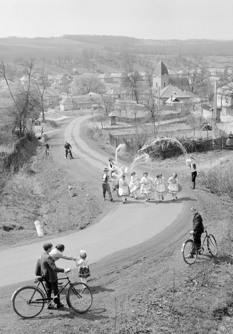 Szente, 1971. április 12. Ünnepi palóc népviseletbe öltözött lányokat vízzel locsolnak a legények. A Nógrád megyei faluban még él az eredeti húsvéti népszokás, hogy nem kölnivízzel öntözik a lányokat.